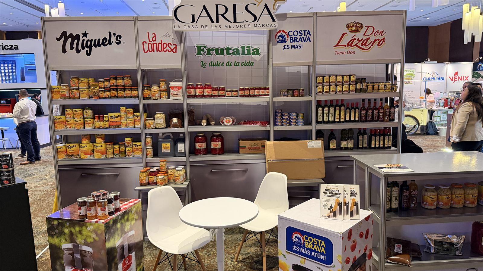 Stand de Garesa en una feria, con estantes de Miguel’s, La Condesa, Frutalia, Costa Brava y Don Lázaro.