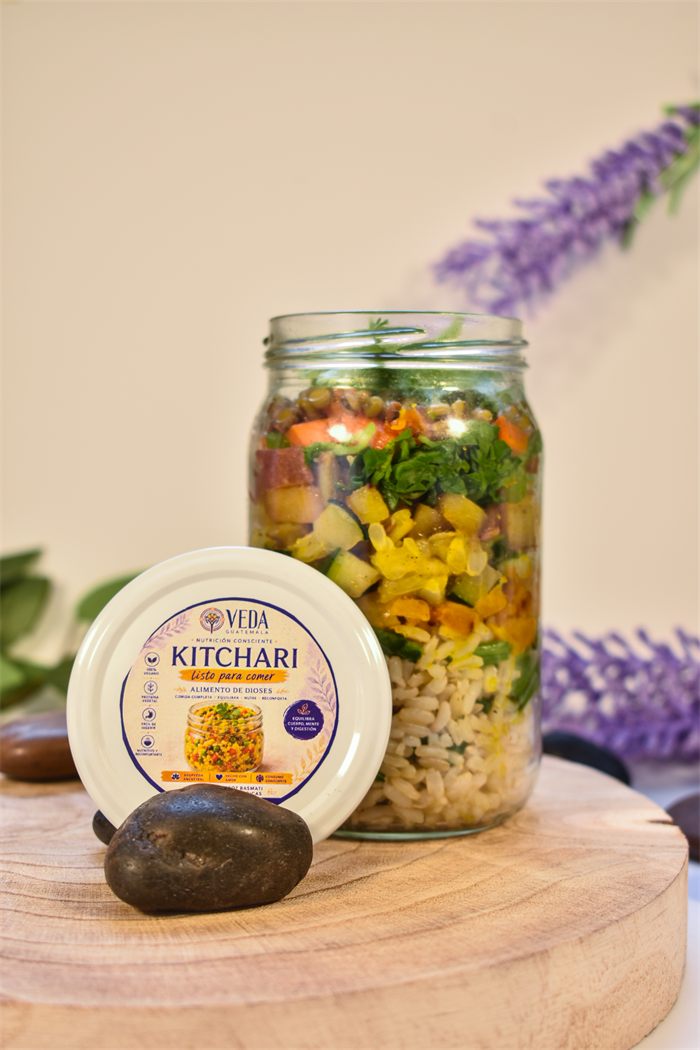 Frasco de kitchari de VEDA sobre una base de madera, con piedras y lavanda de fondo.