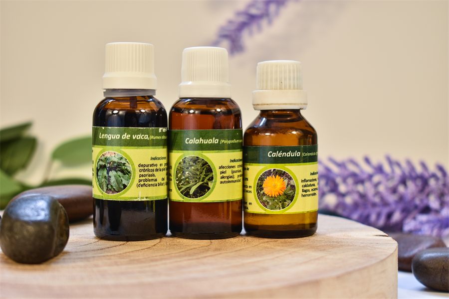 Tres frascos de extractos naturales del trío para la piel, sobre una base de madera con lavanda de fondo.